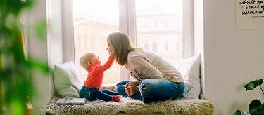 Woman sitting with child near window