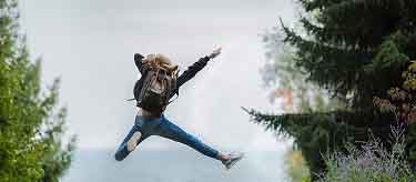 woman jumping with backpack