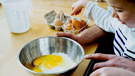 Kid cracking egg.