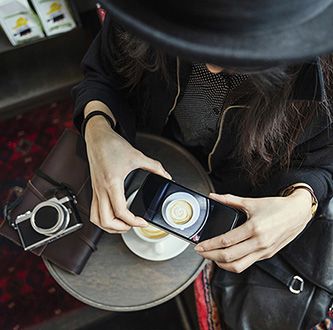 Woman photographing coffee.