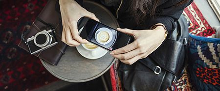 Woman photographing coffee.